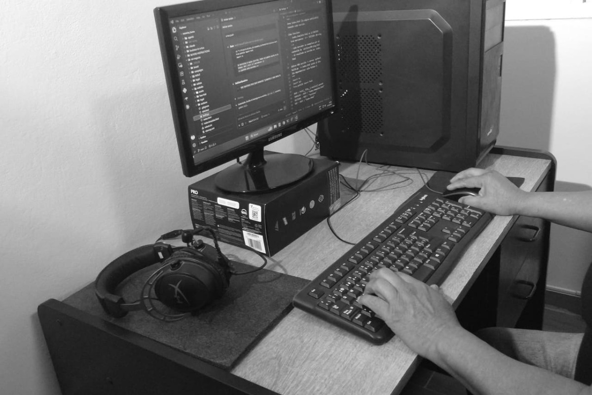 Manos de José Paz escribiendo en el teclado de su escritorio.
